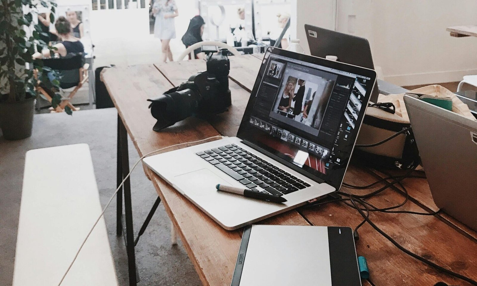pexels-photo-699459-699459 A bright, modern workspace featuring laptops, a camera, and a drawing tablet in an indoor office.